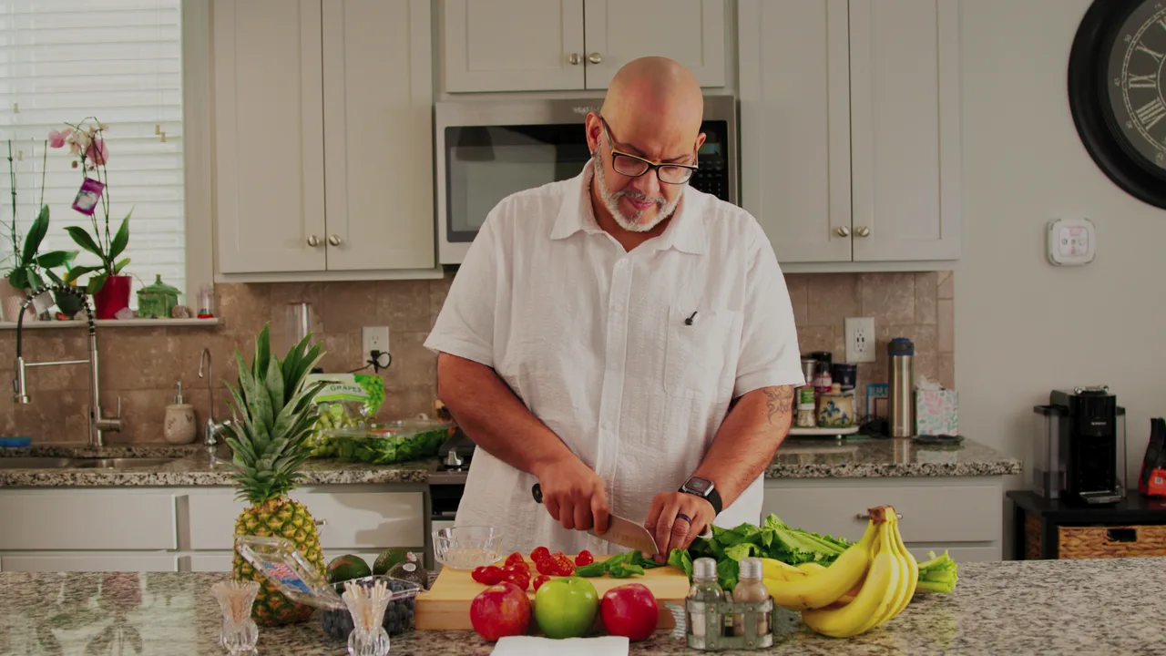 Patrick preparing fresh vegetables and fruit in his kitchen while building healthier habits